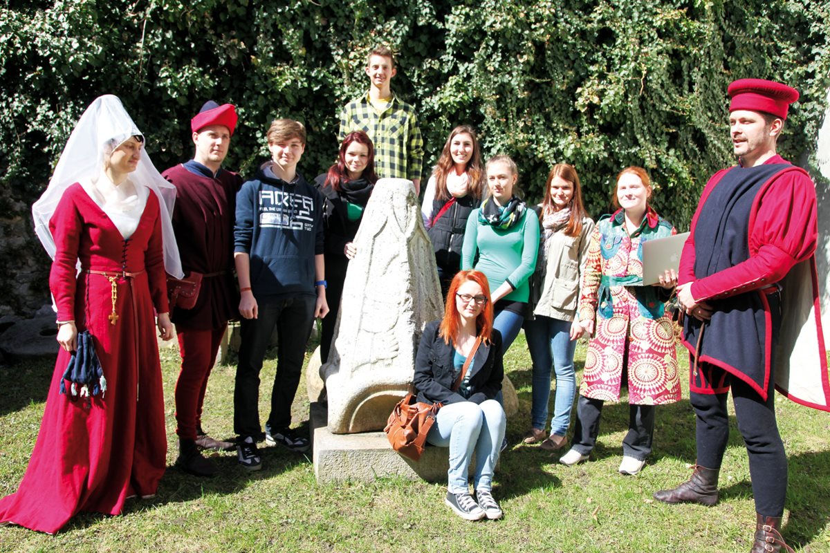 SchülerInnen und LehrerInnen der CHS Villach vor einer Statute beim Stadtmuseum.