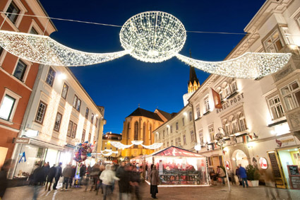Adventmarkt in Villach mit Weihnachtsbeleuchtung am Abend