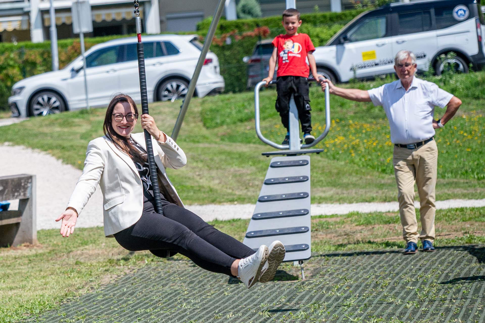 Frau auf Seilrutsche mit Kind und Mann in einem Park in Österreich