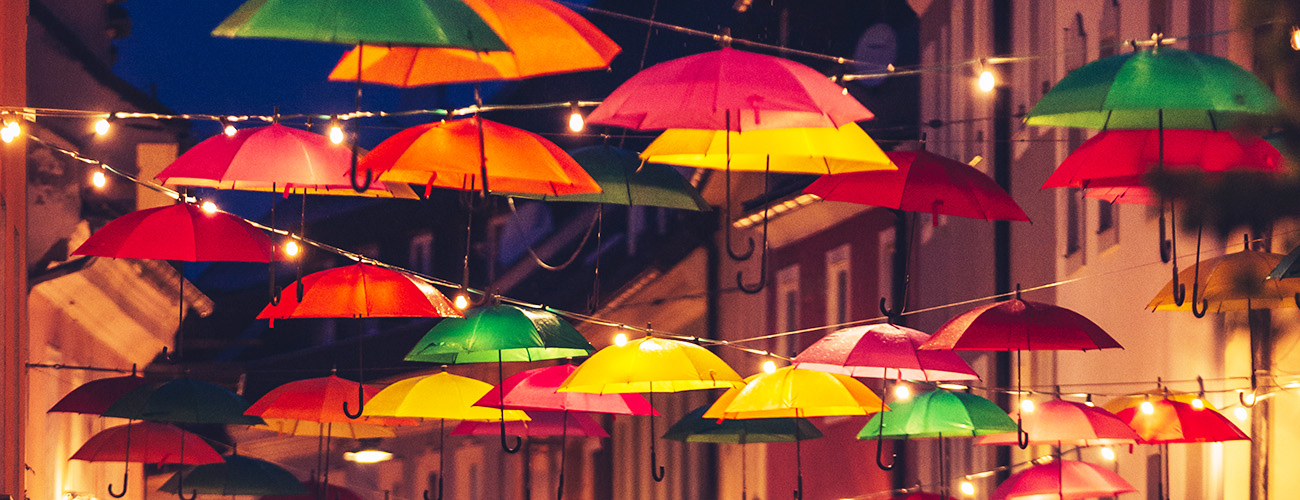 Schirme, welche zusammen mit Lichterketten von Haus zu Haus gespannt sind.