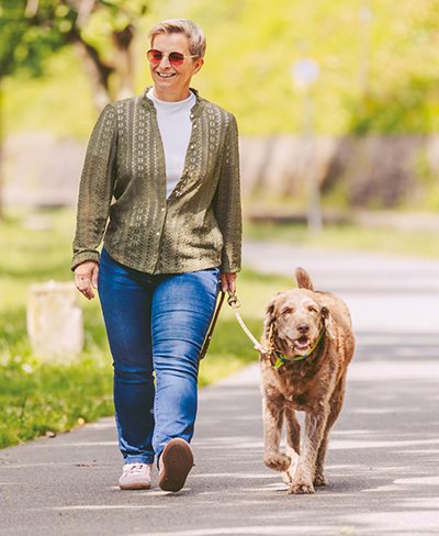 Hund und Frauchen spazieren am Radweg