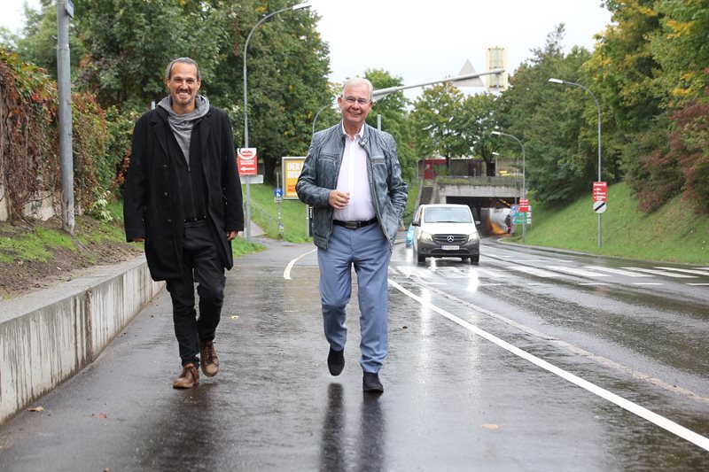 Von links Stadtrat Sascha Jabali Adeh und Stadtrat Harald Sobe gehen auf einem Geh- und Radweg in Villach Lind. 