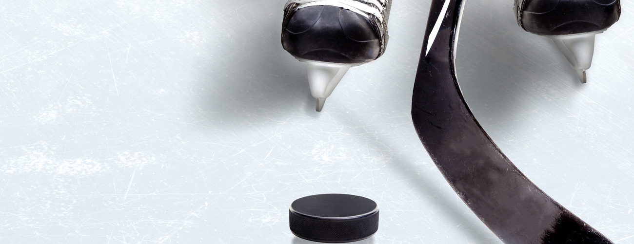 Eishockeyschuhe, Eishockeyschläger und Puck am Eis