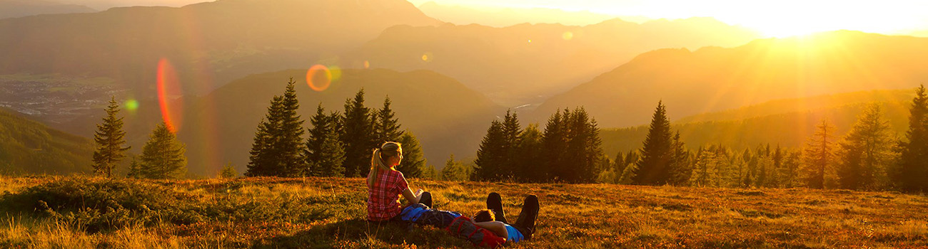 Ein Paar sieht sich den Sonnenuntergang in den Bergen an