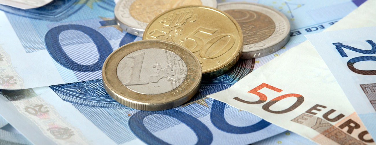 50 und 20 Euro-Scheine und 1 Euro, 2 Euro und 50-Cent Münzen auf einen Haufen.