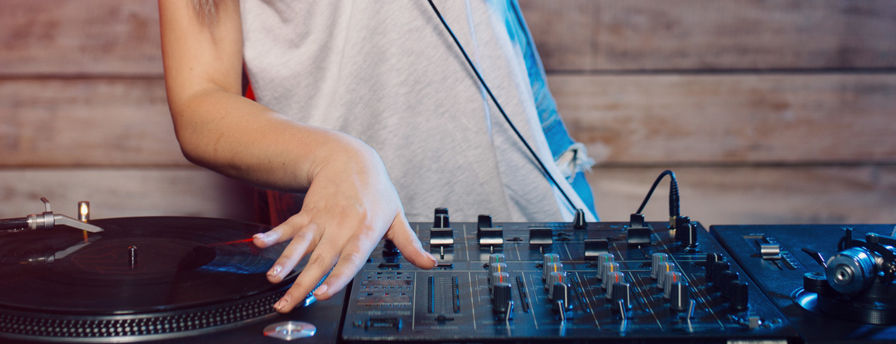 Ausschnitt von einem DJ Pult wo gerade eine Frau auflegt