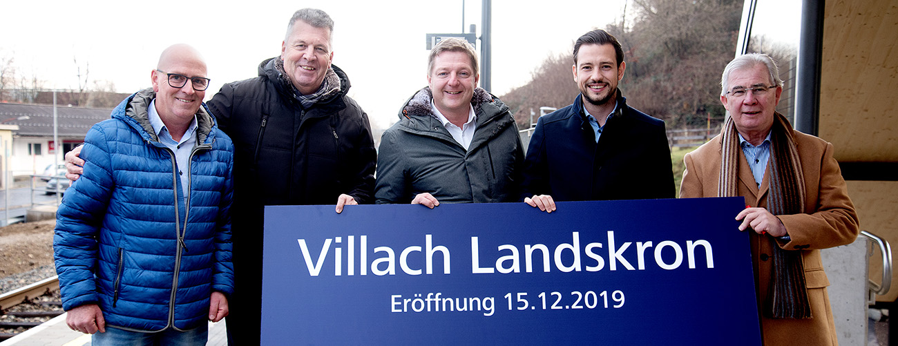 Mehrere Personen halten ein Schild mit der Aufschrift "Villach Landskron"